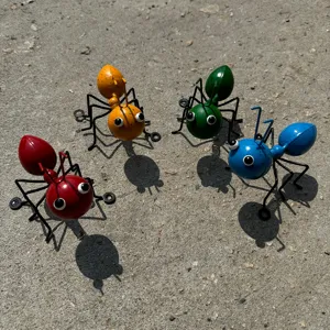 Detail view of colorful metal ant figurines, outdoor garden iron art insect sculptures.