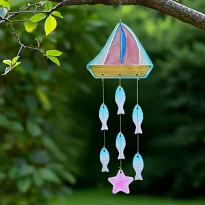 Detailed shot of a colorful glass sailboat and fish wind chime hanging outdoors.