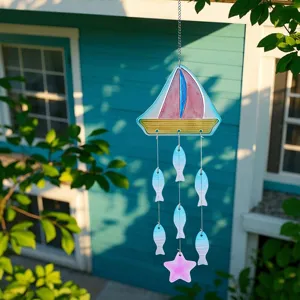 Detailed view of a colorful glass sailboat wind chime with fish and star pendant for garden decor.