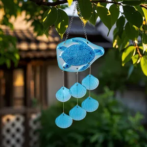 Detailed view of handmade blue stained glass sea turtle wind chime hanging in garden, lovely decor.