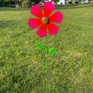 Metal flower garden stake detail showing vibrant red petals and green stem in outdoor grass.