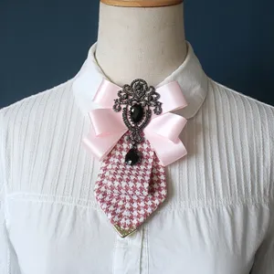 Fiocco collo pied-de-poule rosa vintage con dettaglio spilla di cristallo elegante.