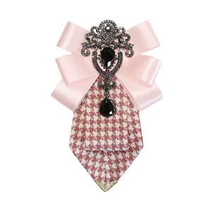 Primo piano del fiocco rosa e della spilla pied-de-poule con ciondolo in cristallo nero.