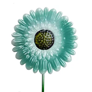 Turquoise metal flower garden stake detail showing textured petals and black center.