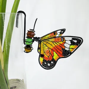Gros plan détaillé d'un papillon coloré en fil de métal et verre pour pot de fleurs.