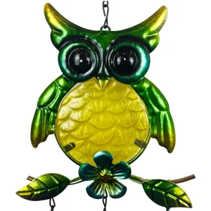 Close-up detail of the metal and glass owl wind chime with vibrant green and yellow painted finish.