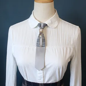 Collegiate style grey plaid necktie with rhinestone pearl and metal chain accessory.
