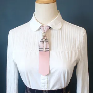 Detail view of the academy style pink plaid tie featuring vintage rhinestone and pearl chain.