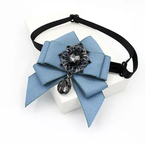 Detailed view of the blue ribbon bow tie featuring a vintage black rhinestone crystal pendant.