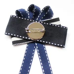 Navy style ribbon bow brooch back view, fabric and metal pin fastener for apparel decor.