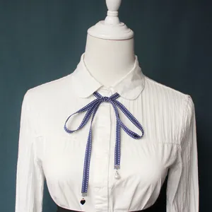 Women college style blue polka dot ribbon bow tie with white long sleeve blouse shirt top.