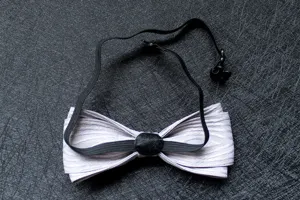 Dettaglio in primo piano dell'elegante farfallino grigio a doppio strato con fascia elastica.