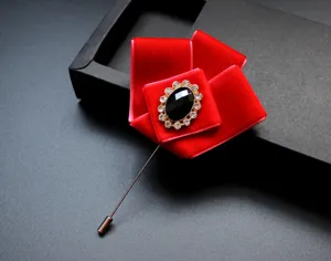 Prachtige rode fluwelen bloembroche met zwart strass midden voor elegante herenpakken.