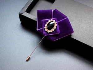 Gedetailleerde close-up van een luxe paarse fluwelen strik broche met strass steentjes.