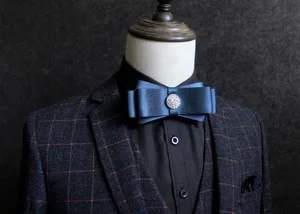 Men's dark blue satin bow tie with rhinestone crystal center, perfect for wedding suit detail.