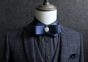 Detail view of a classy navy blue satin bow tie with rhinestone center for men's formal suits.