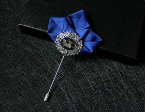 Close-up detail of dark blue fabric flower lapel pin with silver crystal vintage base.