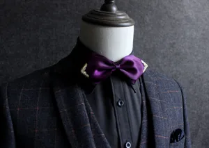 Farfallina uomo in raso viola con decoro metallico dorato sugli angoli, ideale per abiti formali.