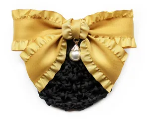 Detailed close-up of a golden ribbon hair bow with pearl pendant and black snood net for work.