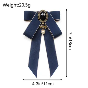 Dark blue JK bow tie brooch for women, elegant vintage style with pearl and black gem pendant.