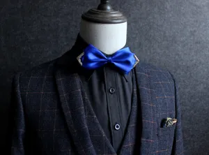 Inquadratura dettagliata di un elegante papillon in raso blu con angoli metallici sul vestito.