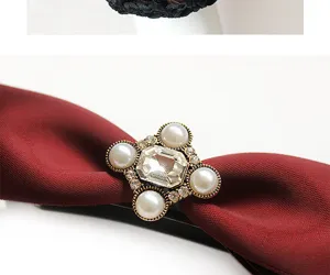 Dettaglio di una molletta per capelli con fiocco rosso vintage e perle per acconciature eleganti.