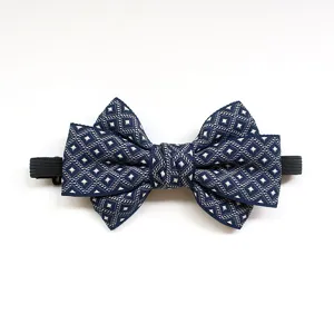 Close-up view of children bow tie, detailed navy blue fabric with white geometric pattern texture.