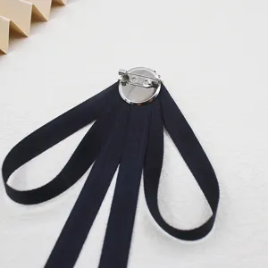 Black ribbon bow tie brooch back detail, classic JK uniform accessory for shirt decoration.
