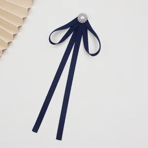 Detailed view of dark blue JK uniform ribbon bow tie with pearl crystal brooch collar accessory.
