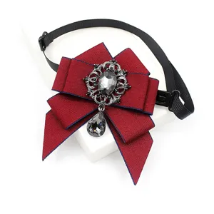 Details of vintage burgundy ribbon bow tie with sparkling crystal pendant and adjustable black strap.