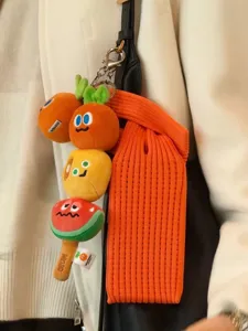 Plush fruit vegetable keychain detail view, soft knitted mobile phone bag strap pendant.