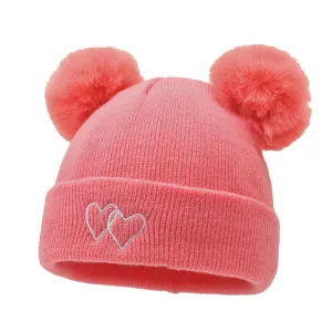 Cute infant knit hat with double pom poms and sweet heart embroidery for warm winter wear.