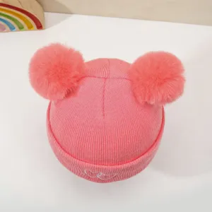 Cute baby knitted hat with double pom-poms and heart embroidery for winter warmth and comfort.