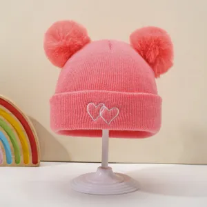 Cute baby knit beanie with double pom poms and sweet heart embroidery for cozy winter warmth.
