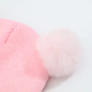 Pink baby knit hat with fluffy pom pom, soft and warm winter cap for cute infants.