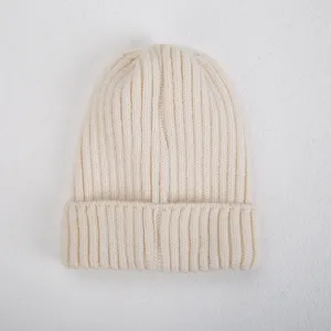 Primer plano de la fina textura de punto acanalado en este acogedor gorro beige detalle.