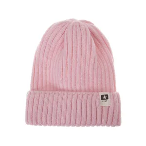 Detalle de gorro de punto rosa, vuelta de canalé con parche de logo de estrella, gorro de invierno.