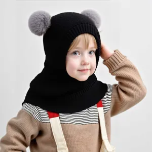 Close-up detail of a soft knit balaclava style kids hat with cute grey pom pom ears.