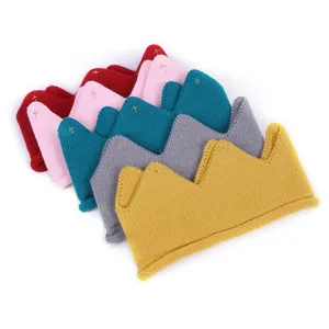 Detailed shot of cute knitted crown headbands for kids, assorted colors, soft wool texture.