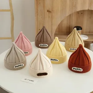 Vista detallada de adorables gorros de punto para bebés con diseño en punta y etiqueta tejida.