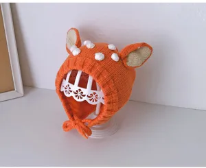 Süße Baby Strickmütze mit niedlichen Hirschohren und weißen Punkten für den Winter.