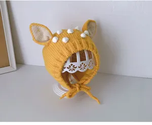 Süßes gelbes Strick-Babyhütchen Detail, Ohren und Bommeln, weiche warme Wintermütze