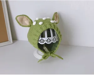 Süße Babystrickmütze mit Tierohren und weißen Pompons, warme Winterohrenklappenmütze.