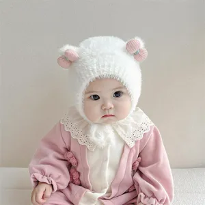 Gedetailleerd overzicht van de schattige winter baby pluche muts met roze pompons en oorkleppen.