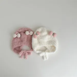 Schattige pluche winterbabymuts met schattige strikjes en warme oorkleppen voor kleintjes.