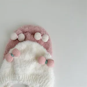 Detail baby pluche wintermuts, dik gebreid oorflappen ontwerp met mooie strikjes voor warmte.