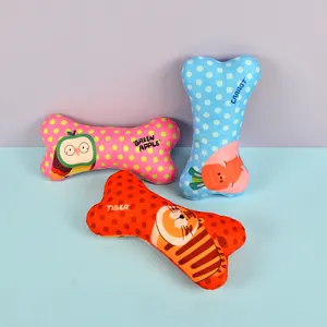 Cute bone-shaped pet plush chew toys detail view featuring colorful polka dots and animal prints.