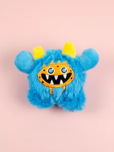 Detailed view of the cute blue monster plush toy with sharp teeth and yellow horns. Soft material.