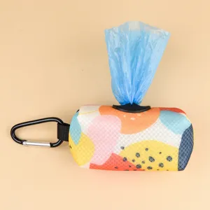 Closeup detail of portable pet waste bag dispenser with colorful abstract print and carabiner.