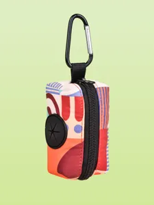 Detail view of a colorful geometric print pet waste bag holder with carabiner and zipper.